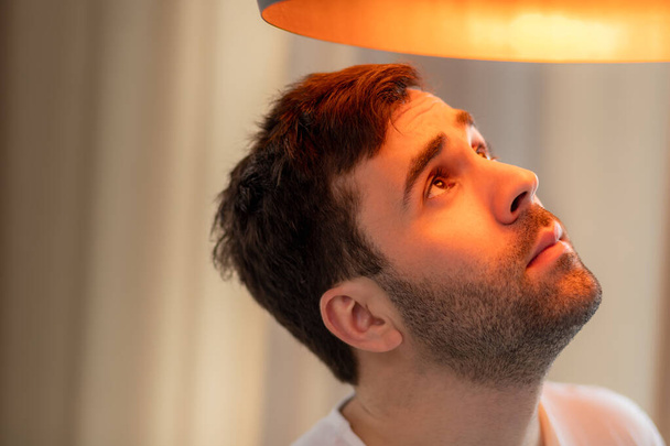 Photo of bearded man looking at big lamp. - Fotografie, Obrázek