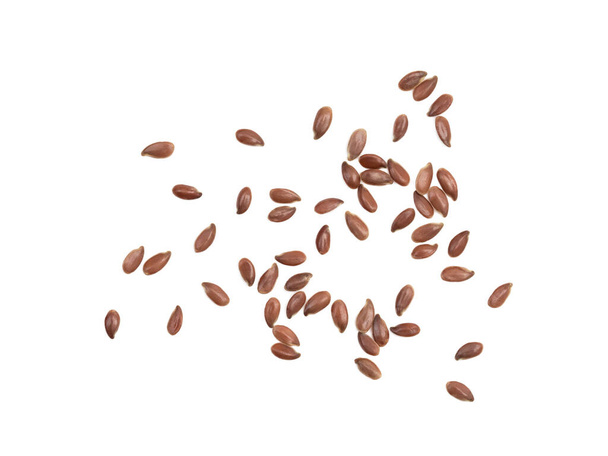 Close up of spread out linseed or flax seed seen directly from above and isolated on white with shadows - Photo, Image