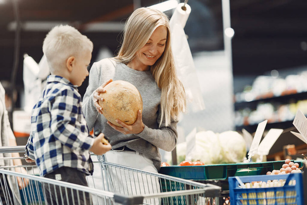 Woman at the supermarket with her son - Foto, Imagen