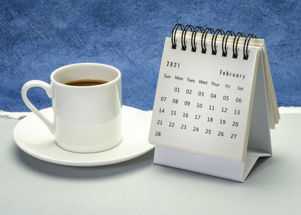 February  2021- spiral desktop calendar against handmade paper with a cup of coffee, season,  time and business concept - Foto, afbeelding
