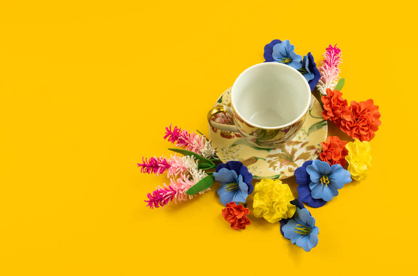 Een serie foto 's met prachtige composities op een gele achtergrond rond het thema ontspanning, theedrinken, gezellige stillevens met bloemen en een decoratieve set, een kop en schotel - Foto, afbeelding