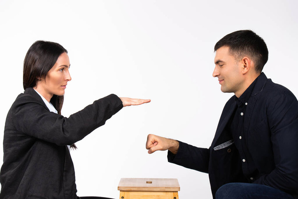 A strong woman wins a battle with a man. Business partners and business game on a white background. High quality photo - Zdjęcie, obraz