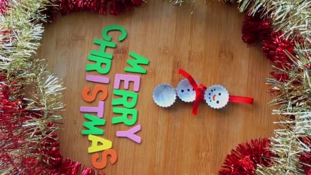 Γραπτό κείμενο με Καλά Χριστούγεννα λέξεις σε ξύλινο πίνακα - Πλάνα, βίντεο