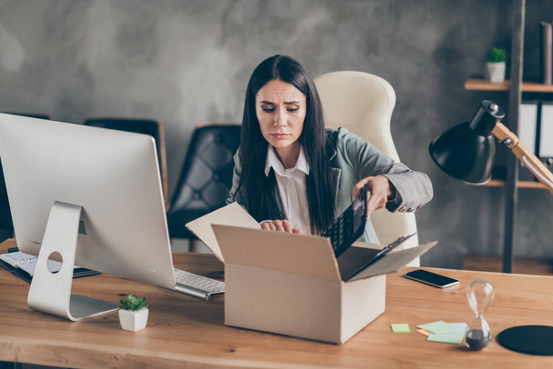 Photo of frustrated upset girl agent collar representative collect her belongings lost job quarantine company crisis sit desk table in workplace workstation office - Фото, зображення