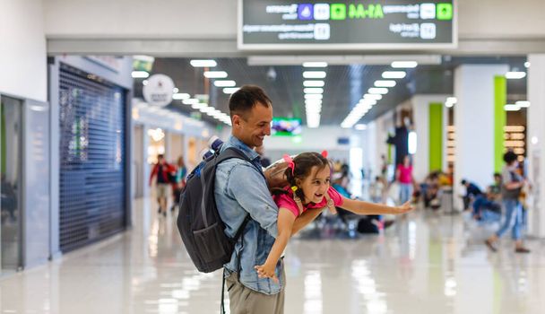Klein meisje met haar vader achtergrond vlucht informatie op de luchthaven - Foto, afbeelding