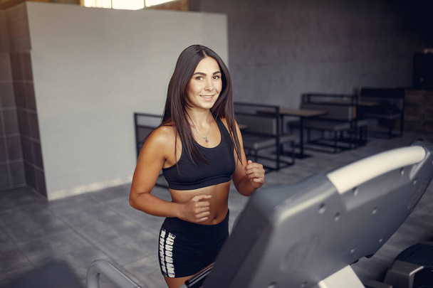 Sports brunette in a sportswear training in a gym - Foto, Imagem