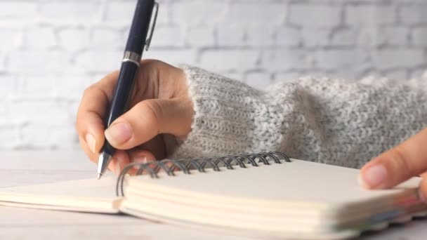 Primo piano delle donne scrittura a mano su blocco note. - Filmati, video