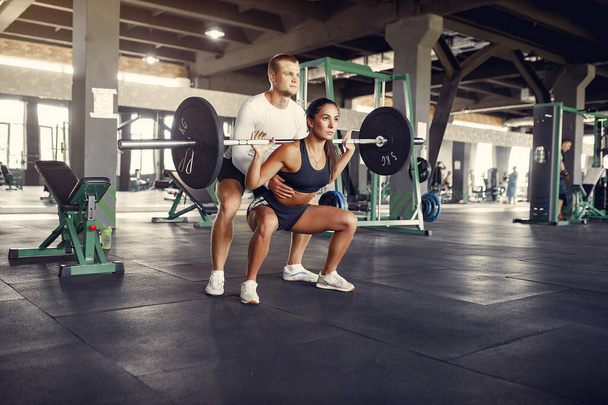 Sports couple in a sportswear training in a gym - Fotografie, Obrázek
