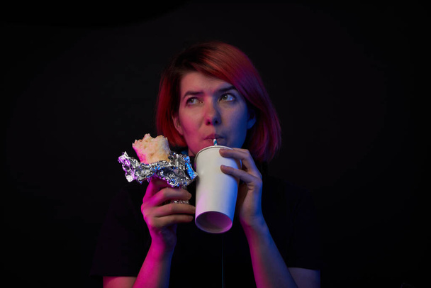 Spielerfrau isst Fast Food und trinkt Cola. Konzept der virtuellen Realität, Spiele, Unterhaltung und Kommunikation. - Foto, Bild