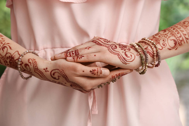 Beautiful woman with henna tattoo on her hands outdoors, closeup - Photo, Image