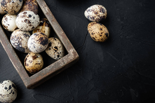Βιολογικά αυγά ορτύκια, πάνω όψη, σε μαύρο υφή φόντο με χώρο αντιγραφής - Φωτογραφία, εικόνα