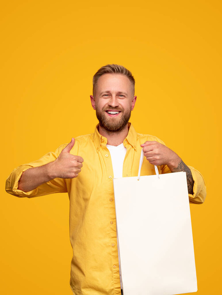 Excited man showing thumb up for successful purchase - Foto, immagini