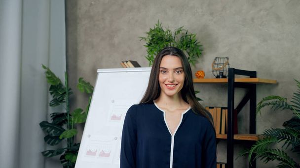 Smiling attractive woman business coach looking camera on background whiteboard - Fotoğraf, Görsel