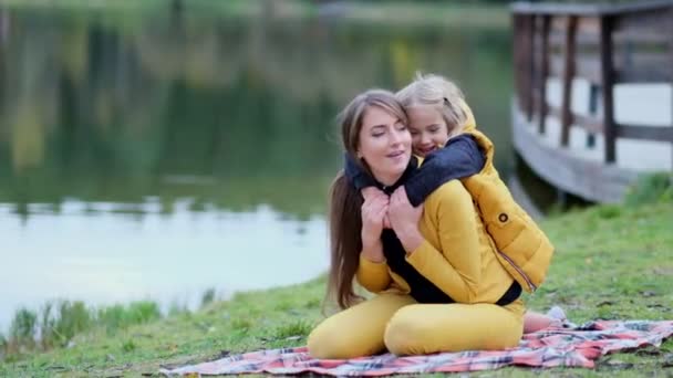 Beautiful and happy young mother giving piggyback ride to her laughing daughter. Slow motion video. stock footage - Footage, Video