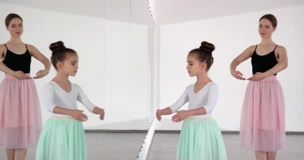 Маленькая балерина тренируется с тренером в танцевальной студии - Кадры, видео