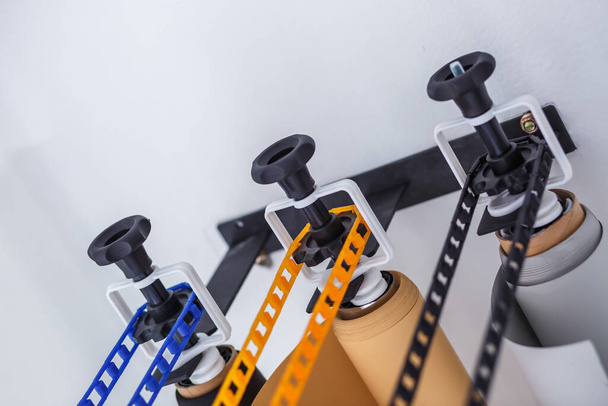 mounting manual support system for photo backdrops in modern studio. Rolls of colorful paper backgrounds for photo studio hang on the wall - 写真・画像