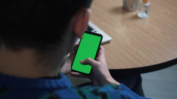 Egy zöld képernyős telefon közelsége. Chroma kulcs az okostelefon képernyőjén. Egy férfi információt görget a képernyőn. Kattintások és húzások. - Felvétel, videó