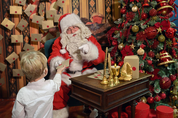 Ένα αγόρι με κοχλιακά εμφυτεύματα και ο Άγιος Βασίλης στο Studio - Φωτογραφία, εικόνα
