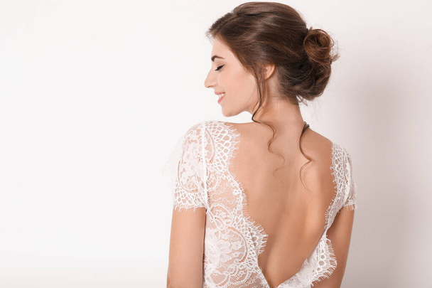 Young bride wearing beautiful wedding dress on light background - Foto, Imagem
