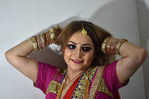 mariée indienne en robe traditionnelle montrant ses cheveux bruns - Photo, image