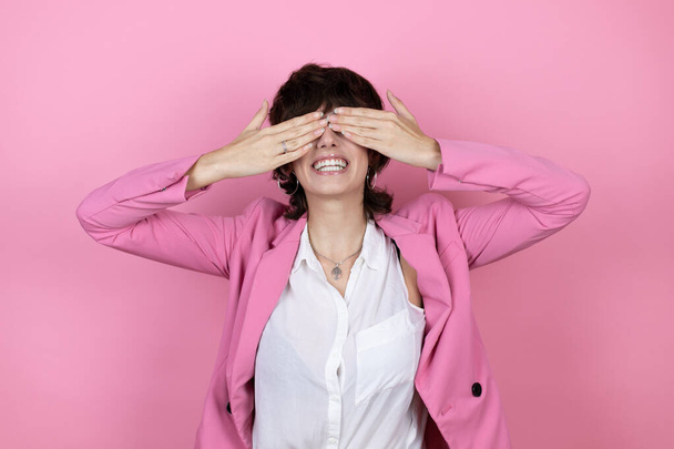 Young business woman over isolated pink background covering eyes with hands smiling cheerful and funny. Blind concept. - Fotoğraf, Görsel