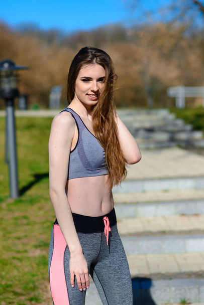 A close up of attractive young woman running, doing fitness outdoors - Valokuva, kuva