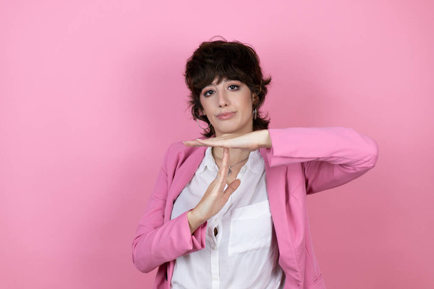 Jovem mulher de negócios sobre fundo rosa isolado Fazendo tempo fora gesto com as mãos, rosto frustrado e sério - Foto, Imagem