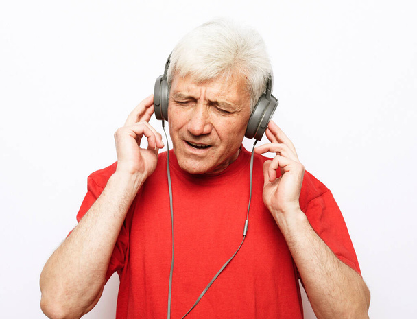 Old man listening to music on his headphones. - Фото, зображення