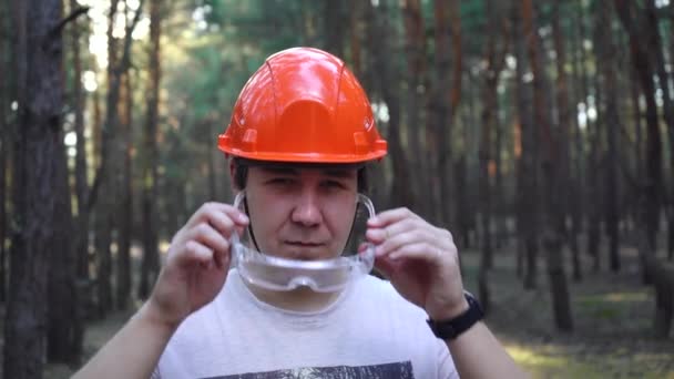 obrero de la construcción hombre con casco se pone gafas - Imágenes, Vídeo