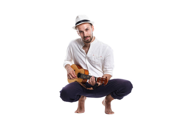 Atraente jovem caucasiano macho com ukulele isolado no fundo branco. - Foto, Imagem