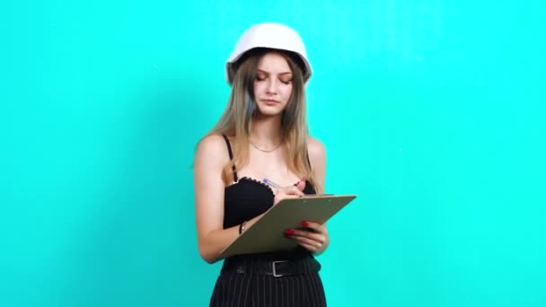 Female engineer makes notes on a sheet, analyzing construction works - Πλάνα, βίντεο
