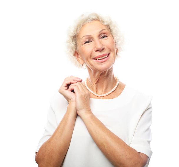 Cheerful elderly woman standign on white background - Fotó, kép