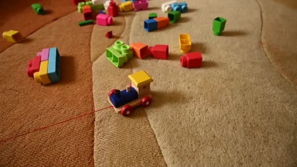 Farbige Spielzeugeisenbahn, auf einem Hintergrund aus farbigem Spielzeug - Filmmaterial, Video