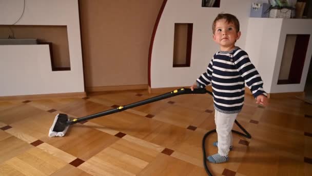 A gyerek lemossa a padlót. Takarító gyerek. Kiváló minőségű videó - Felvétel, videó