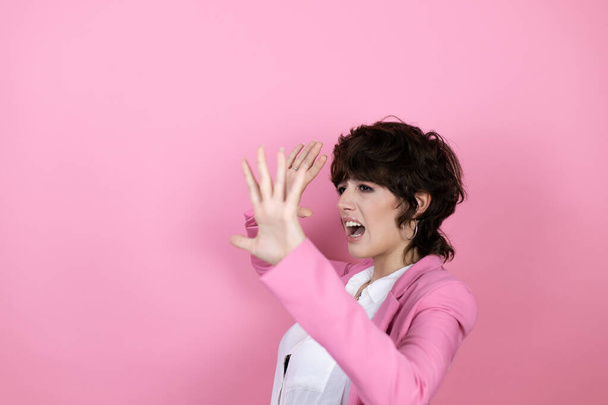 Jeune femme d'affaires sur fond rose isolé effrayé avec ses bras vers le haut comme quelque chose qui tombe d'en haut - Photo, image