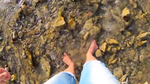 Mädchen läuft barfuß auf Steinen des flachen Flusses in Nahaufnahme, sonniger Sommertag - Filmmaterial, Video