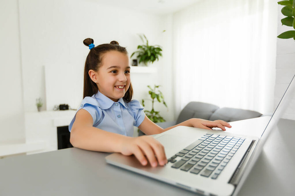 Pretty stylish schoolgirl studying homework math during her online lesson at home, social distance during quarantine, self-isolation, online education concept, home schooler - Foto, Imagem
