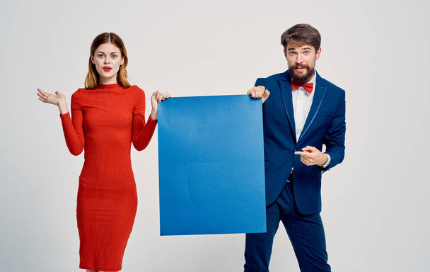 Kobieta w czerwonej sukience elegancki mężczyzna w garniturze z niebieskim arkuszem papieru w rękach agencji reklamowej - Zdjęcie, obraz