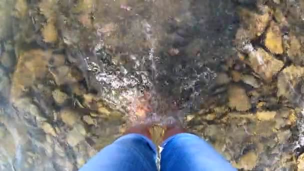 Chica está descalza en piedras río poco profundo - Metraje, vídeo