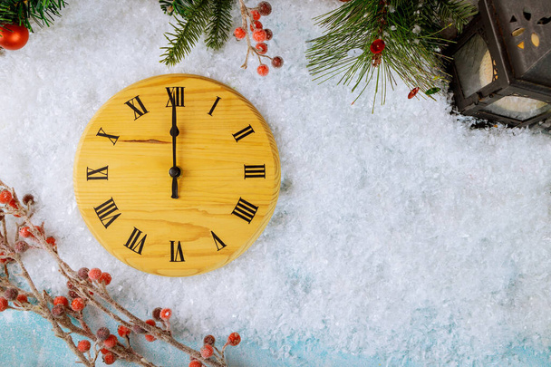 Αντίστροφη μέτρηση προς τα μεσάνυχτα ρολόι στυλ ξύλου μετράει τελευταίες στιγμές πριν από την Πρωτοχρονιά χριστουγεννιάτικο φανάρι με κουκουνάρι, νιφάδες χιονιού και μπάλα - Φωτογραφία, εικόνα