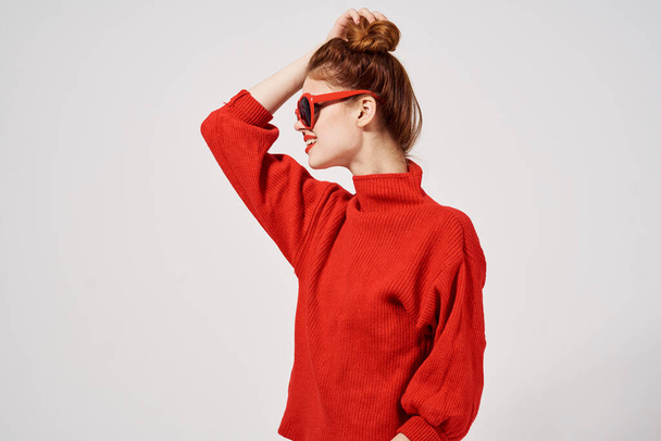 μοντέρνα γυναίκα μοντέλο σε κόκκινο πουλόβερ και γυαλιά ηλίου gesturing με τα χέρια της - Φωτογραφία, εικόνα