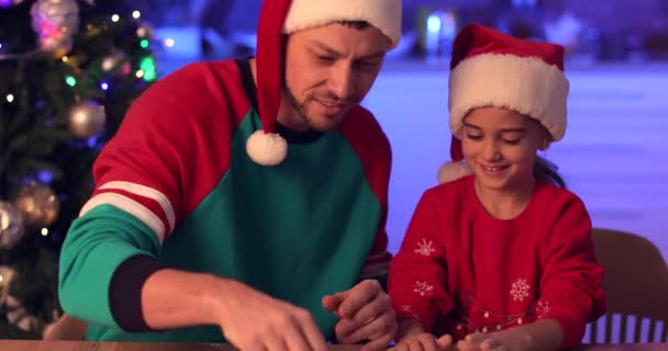 Happy father and his little daughter making gingerbread cookies for Christmas in kitchen - Footage, Video