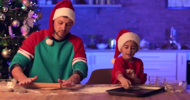 Boldog apa és kislánya mézeskalács sütit készítenek karácsonyra a konyhában. - Felvétel, videó