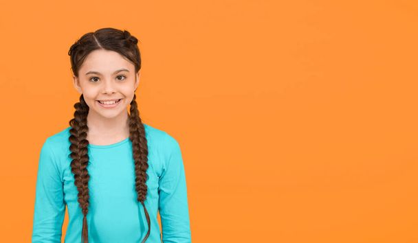 happy child girl with healthy smile has fashionable hairstyle on yellow background, happiness - Zdjęcie, obraz