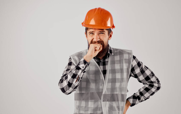 Άνθρωπος στην κατασκευή ομοιόμορφη πορτοκαλί σκληρό καπέλο συναισθήματα ενός επαγγελματία οικοδομών - Φωτογραφία, εικόνα