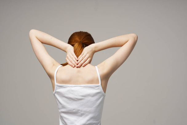 femme t-shirt touche son dos avec les mains vue arrière Espace de copie - Photo, image