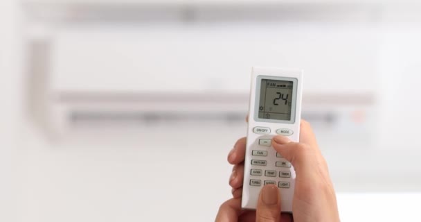 Mulher ajustando a temperatura do condicionador de ar que está operando no modo de aquecimento, close-up - Filmagem, Vídeo
