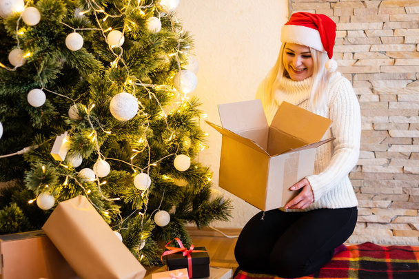 Boldog fiatal nő kinyitja a karácsonyi ajándék doboz - Fotó, kép
