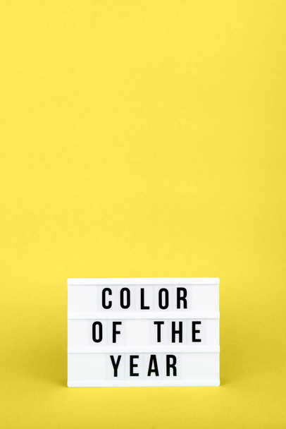 Caja de luz retro con la redacción Color del año en el fondo amarillo sólido de moda - Foto, imagen