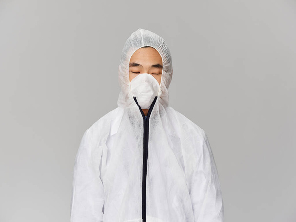 Hombre asiático apariencia médica ropa protección coronavirus gris fondo - Foto, imagen